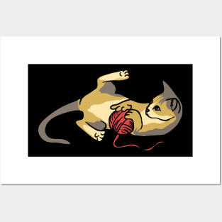 A cute cat playing with red wool Posters and Art